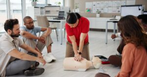 first aid cpr training people with dummy safety compliance health chest compression breathing paramedic course medical demonstration teaching emergency rescue technique office 590464 525199 1