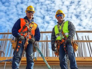 two men wearing safety vests are standing construction site 763111 311828 1