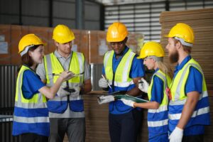 team discusses plans warehouse with safety gear equipment work hours 35752 27945